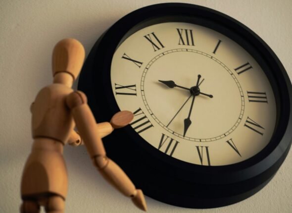 a wooden toy standing next to a clock